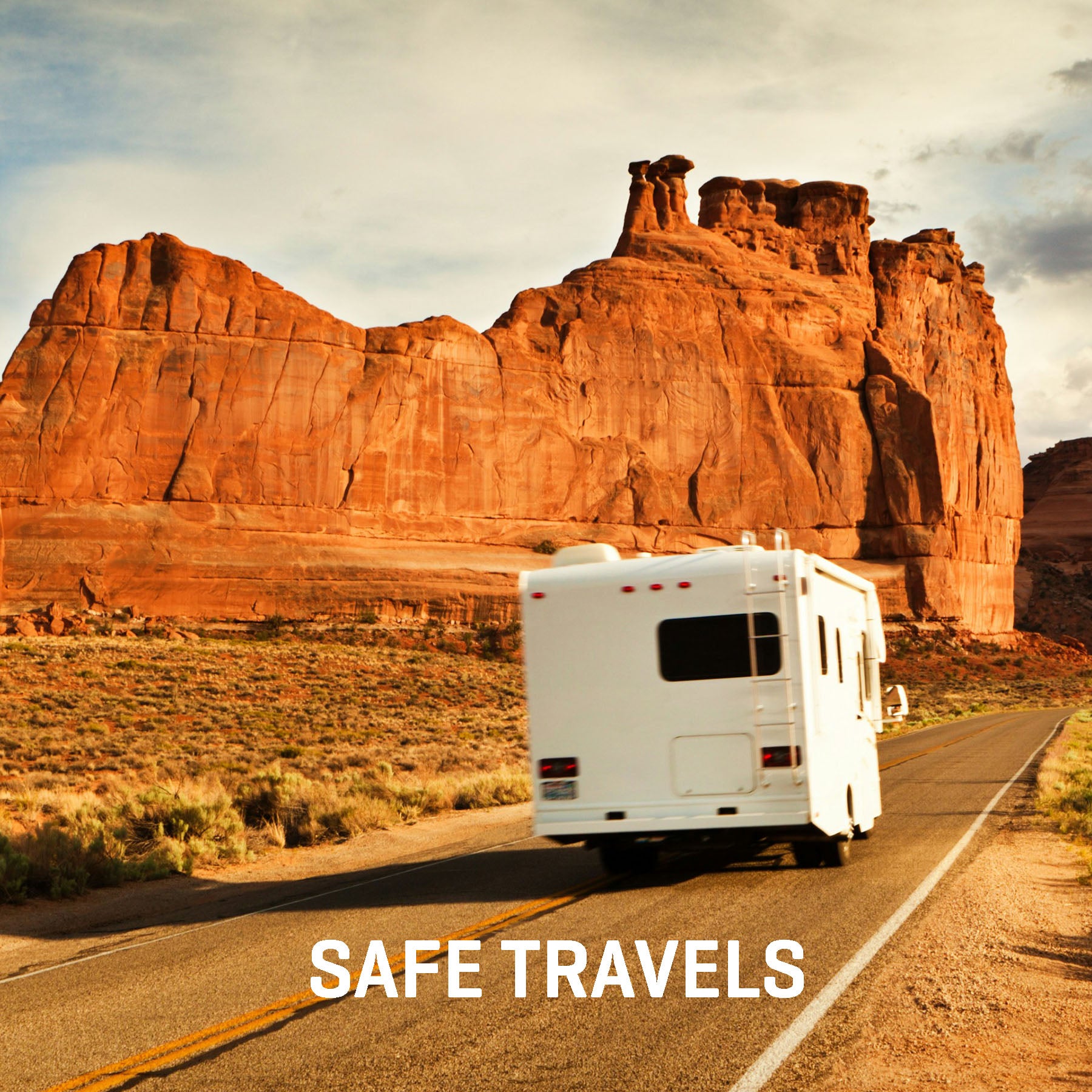 White RV on a desert road with red rock formations and 'Safe Travels' text.